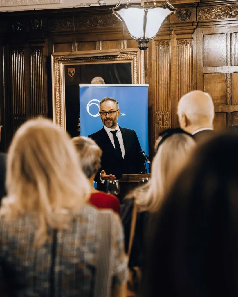 Speaker presenting at a Fair Civil Justice event, with a focus on audience members seated in a conference room.